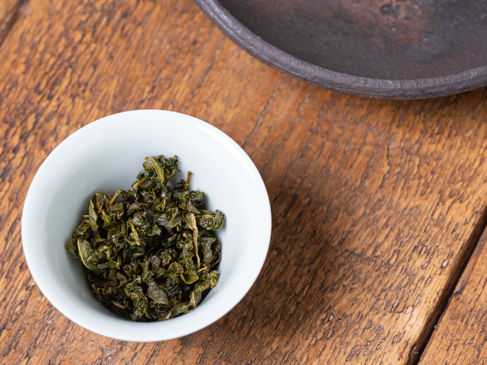 Hojas infusionadas de té oolong high mountain en un gaiwan de porcelana